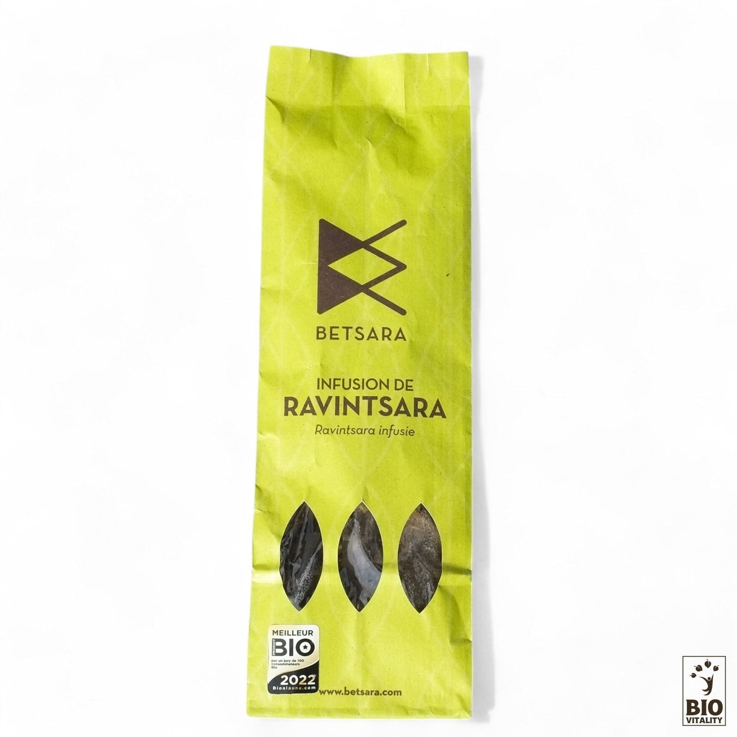 Un sac en papier vert intitulé « BETSARA Feuilles de ravintsara Bio - 50 g » présente trois images de feuilles et un logo « Feuilles de Ravintsara Bio 2022 » en bas, soulignant ses bienfaits naturels.