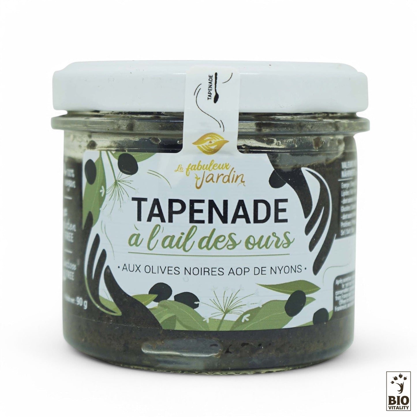 La Tapenade Olives Noires & Ail des ours Bio (90g) de Fabuleux Jardin contient des Olives Noires de Nyons AOP sélectionnées. Elle est présentée dans un pot avec un couvercle blanc et une étiquette verte et noire décorée dolives et dherbes illustrées, ainsi quune étiquette bio au fond.