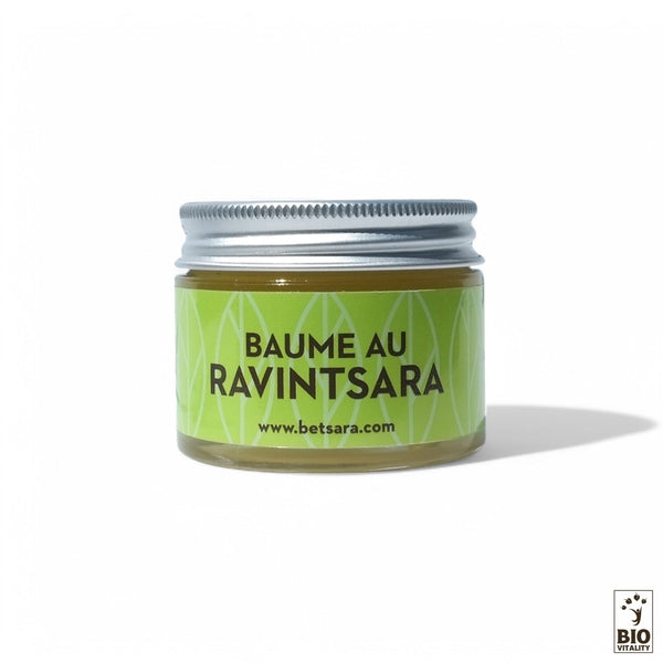 Un petit pot de 30 ml étiqueté « Baume Ravintsara - certifié Nature & Progrès » de BETSARA, doté dun couvercle métallique sur fond vert et infusé de beurre de karité apaisant, affiche lURL dun site Web.