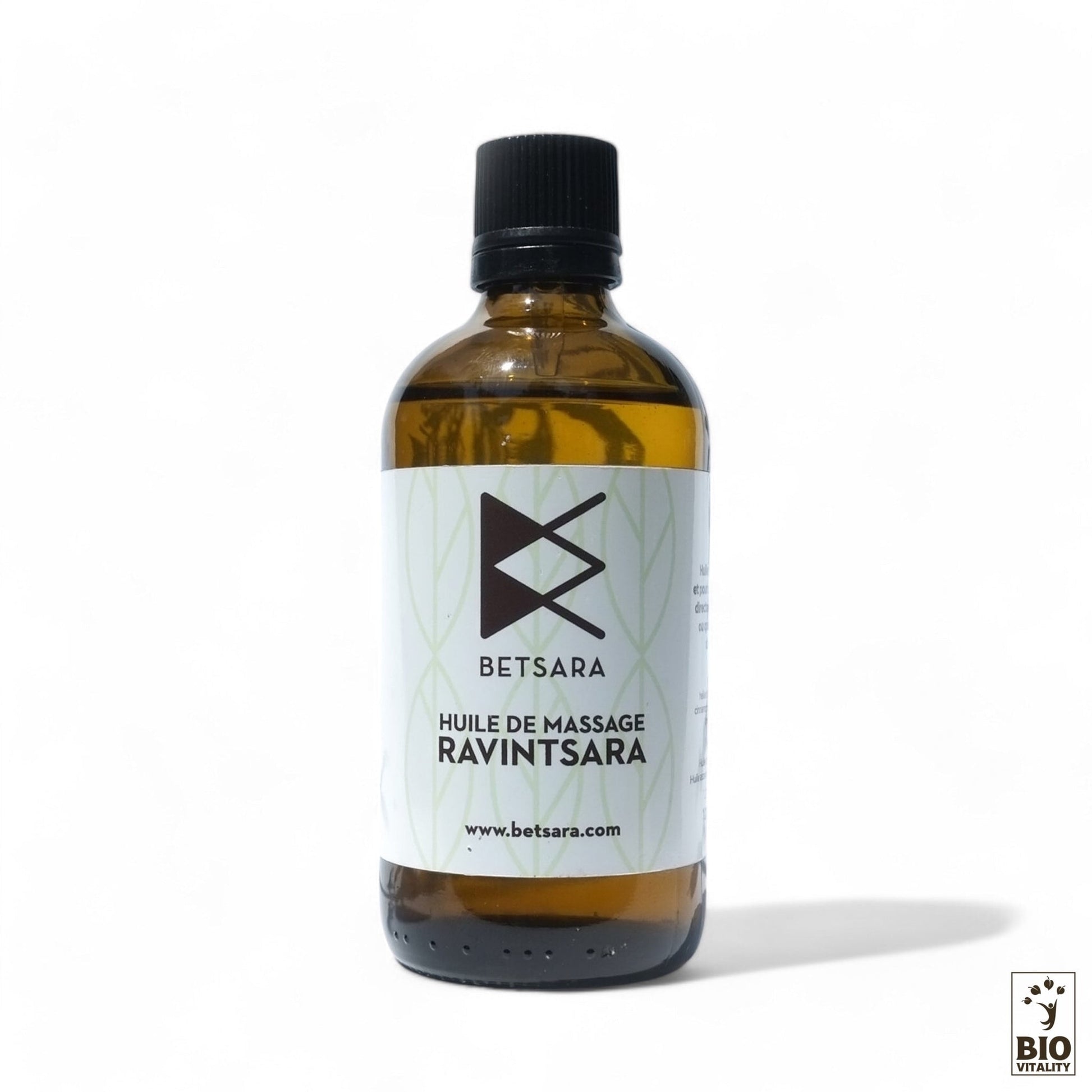Une bouteille en verre dHuile de massage au Ravintsara BETSARA - certifiée Nature & Progrès, dotée dun bouchon noir et dun logo, met en valeur ses ingrédients bio sur un fond blanc épuré.