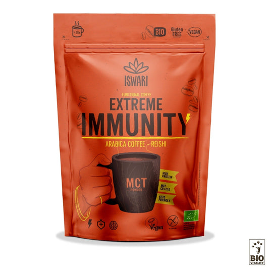Lemballage coloré étiqueté « Super Café Extreme Immunity Bio - 200g » par ISWARI contient du café Arabica avec des champignons Reishi. Les icônes indiquent la noix de coco MCT, le véganisme, le sans gluten et la certification BIO. Une main tenant une tasse fumante illustre le mélange parfait pour renforcer limmunité.