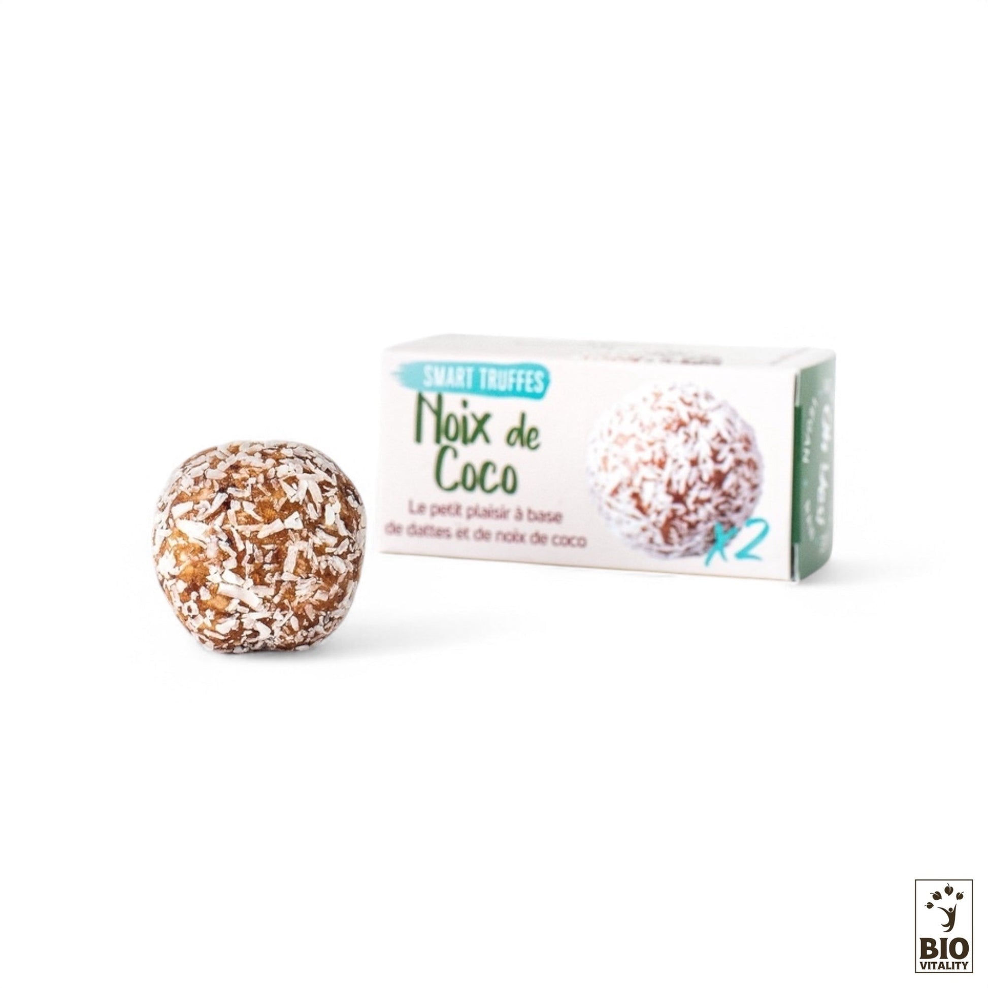 Une truffe à la noix de coco est élégamment positionnée devant une boîte étiquetée « Smart Truffes Noix de Coco - 2 pièces » de LE SMART CAKE, arborant le logo Bio Vitality et soulignant son engagement envers les ingrédients biologiques.