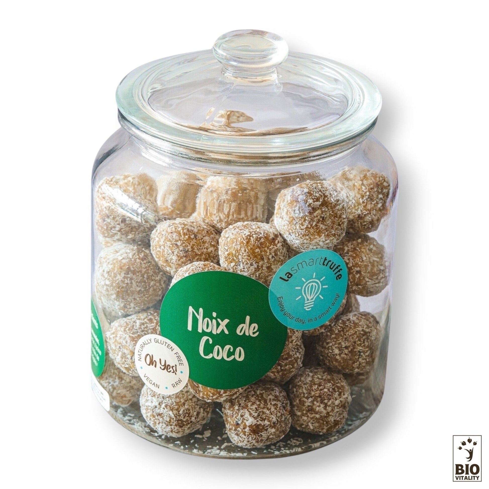 Un pot en verre de 500 g de « Smart Truffes Noix de Coco » de LE SMART CAKE propose des délices enrobés de noix de coco, décorés de « Noix de Coco », portant des autocollants pour la certification sans gluten et biologique.