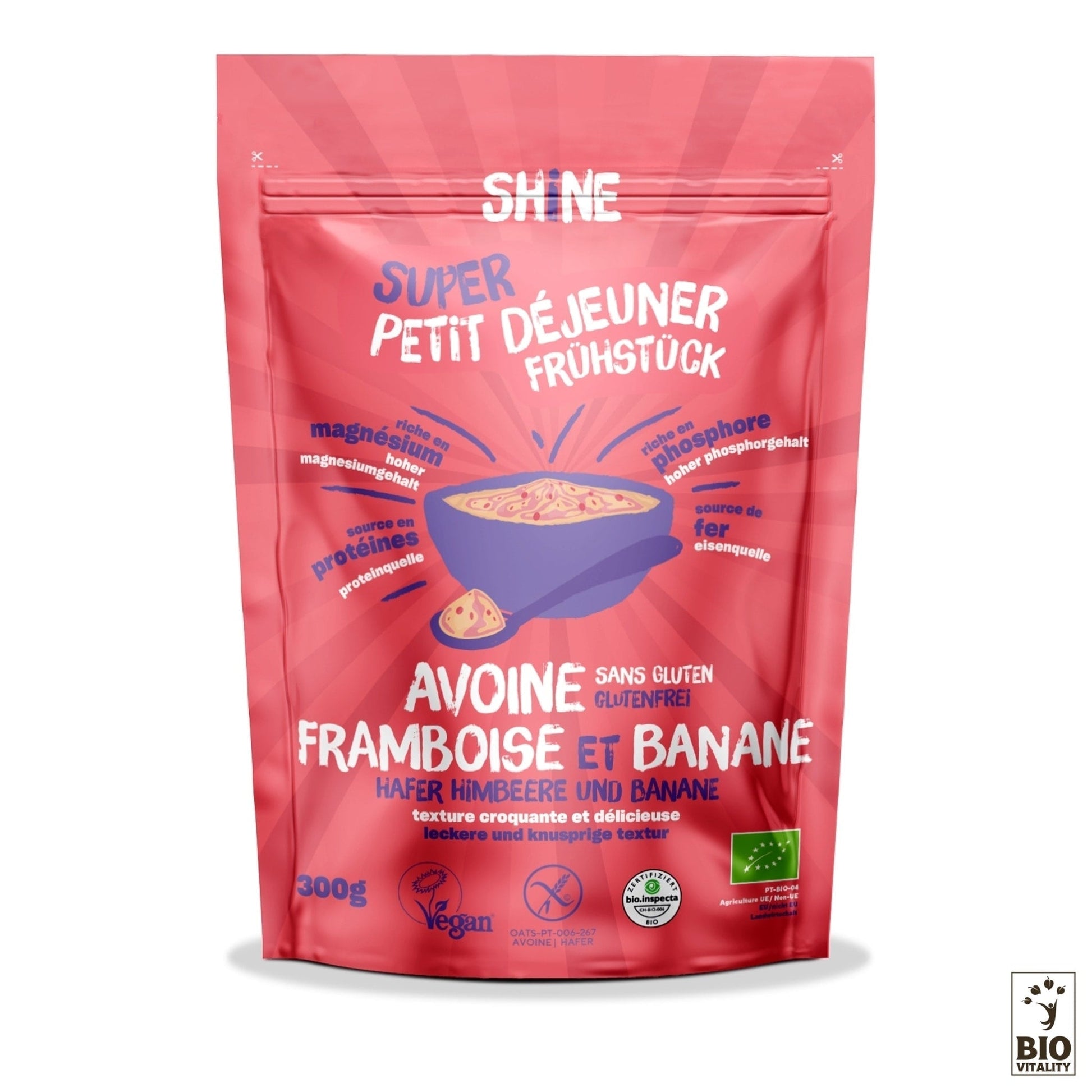 La pochette rouge de SHINE Avoine Framboise et Banane Bio, étiquetée en français et en allemand, propose des super-aliments pour un délicieux petit-déjeuner. Elle contient de lavoine, de la framboise, de la banane et est marquée des icônes vegan et sans gluten. Taille du paquet : 300g.